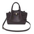 Detail view of dark coffee pebbled leather tote with gold accents and wing-inspired folds - Brown