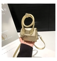 Détail d'un mini sac beige à motif serpent avec une poignée ronde et une bandoulière fine - Or