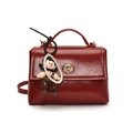 Borsa in pelle cerata rosso scuro con chiusura dorata e ciondolo a forma di bambolina - Con Ciondolo / Rosso Con Ciondolo A Cartone Animato