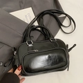 Sac Boston noir brillant élégant avec doubles poignées et bandoulière dans un décor de mode - Sans Pendentif / Noir