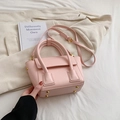 Elegant pink leather bucket bag with top handles and adjustable strap in home setting - Pink