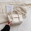 Chic beige bucket bag with gold hardware and trapezoid flap design for women - White