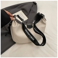 Elegante borsa a mezzaluna beige con ampia tracolla logata su un blazer grigio scuro - Bianco Sporco