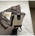 Detail of two-tone bucket bag with lychee texture leather and silver metal twist lock - White and Black