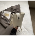 Detail van de roomwitte emmer tas met litchi-korreltextuur en zilveren metalen sluiting - Wit