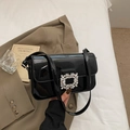 Glossy black patent leather handbag with a large sparkling rhinestone buckle accessory - Black