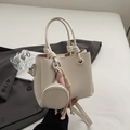 Minimalist cream white bucket bag with pebble leather texture and knotted handle detail - White With Pendant
