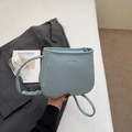 Minimalist light blue bucket bag in litchi grain leather with chic woven strap details - Blue