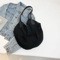 Minimalist black crochet tote bag with mesh hollow design on denim background - Black