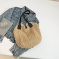Large beige woven knit tote bag with black faux leather handles on a minimal background - Khaki