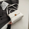 Elegant white litchi textured crossbody bag with golden hardware and round handle - White