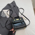 Black woven texture shoulder bag with golden logo plaque and white plush charm accessory - Black With Pendant