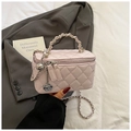 Detailansicht der rosa gesteppten Mini-Tasche mit Kristallnieten und Rosen-Anhänger - Lila