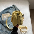 Gelbe Nylon-Umhängetasche mit Kordelzug und Logostickerei auf Jeansjacken-Hintergrund - Gelb