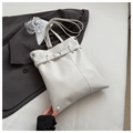 Detalle del bolso de cubo en cuero blanco roto con hebilla plateada y costuras decorativas - Gris