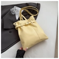 Detalle de bolso tote de cuero amarillo claro con correa decorativa y hebilla metálica - Amarillo