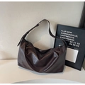 Dettaglio borsa in pelle cerata marrone scuro con texture e tracolla regolabile - Marrone