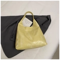Minimalist pale yellow tote bag with smooth satin finish on a grey blazer background - Yellow