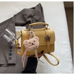 Detail of yellow lychee textured leather mini bag with metal star buckle and teddy bear charm - Yellow