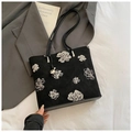Détail du sac seau en tissu noir avec broderie florale blanche et finitions métalliques - Noir