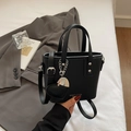Elegante schwarze Eimer-Tasche aus Kieselleder mit Herzanhänger und Schultergurt - Schwarz