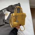 Chic yellow bucket bag with lychee texture, silver studs, and a cute heart pendant - Yellow