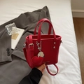 Fashionable red bucket bag with heart pendant and lychee leather texture for women - Ancorra Red