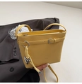 Detail of yellow lychee grain bucket bag with belt buckle and leopard heart charm - Yellow