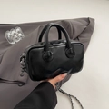 Minimalistische schwarze Lackleder-Baseballtasche mit Silberkette in der Hand gehalten - Schwarz