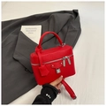 Primer plano de bolso vanity de cuero rojo con grabado de lichi y cierre plateado - Rojo