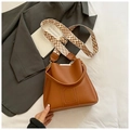 Bolso saco marrón caramelo de cuero con correa tejida geométrica y detalles de metal - Marrón
