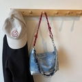 Denim schoudertas met rood-wit touwband en blauw-witte knoopbedel hangend aan de haak - Denim Blauw