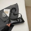 Borsa sottobraccio in vernice nera lucida con rivetti argento e design curvo elegante - Nero
