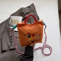 Orangefarbene Beuteltasche mit Dackel-Stickerei und buntem geflochtenem Schultergurt - Orange