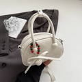 Minimalist off-white bowling bag with ribbon detail and colorful beaded charm - White