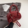 Glossy burgundy patent leather bowling bag with bow detail and adjustable strap - Red