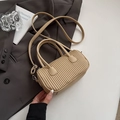 Minimalist beige pleated cylinder handbag with detachable strap on grey suit jacket - Khaki