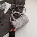 Minimalist light grey pleated cylinder bag with top handles and slender crossbody strap - Gray