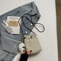 Minimalist beige drawstring crossbody bag with cute plush monster charm for women - Off White