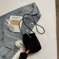 Chic black drawstring bucket bag with a plush monster charm and slim shoulder strap - Black