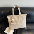 Large beige tote bag in textured PU leather with cute teddy bear charm on black sofa - With Charm / Khaki