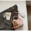 Detail of pink bucket bag with woven texture, metal logo and a cute bear charm accessory - With Charm / Pink