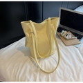 Detail of light yellow croc-embossed tote bag with silver ring hardware and shoulder straps - Yellow