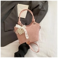 Rosa Beuteltasche mit Spitzenschleife und Perlenherz-Anhänger auf grauem Stoff - Rosa