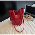Detailansicht einer roten Tasche mit Krokodilprägung in einer modernen Büroumgebung - Rot