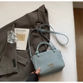 Light blue bucket bag with woven texture, metal letter logo, and adjustable strap - No Pendant / Blue