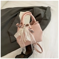 Détail d'un sac seau rose avec grand nœud en dentelle blanche et chaîne de perles chic - Rose Avec Pendentif