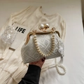 Close-up of vintage embroidery evening bag with large pearl clasp and white tassel details - Off White