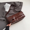 Bolso de hombro minimalista de cuero brillante marrón oscuro con hebilla plateada y ojales - Marrón