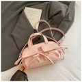 Detailansicht der rosa Schleifenakzente und Taschen an einer stylischen Handtasche - Rosa